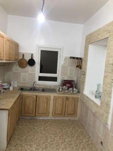 cocina con fregadero y ventana en Dar Chahla, en Tozeur