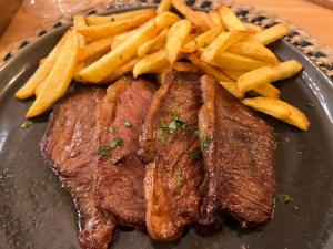 een bord met biefstuk en frietjes op een tafel bij Quintinha da Oliveira in Marco de Canavezes