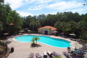 una vista sul soffitto di una piscina con sedie e alberi di Four Bedrooms TownHome 5122 a Kissimmee