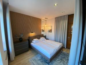 a bedroom with a bed with white sheets and pillows at Aquarius Apartament Ustka in Ustka
