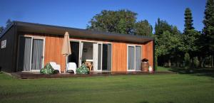 Cette petite maison dispose d'une terrasse et d'un parasol. dans l'établissement Sublime Nooks, à Havelock North