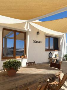 un patio con mesa de madera y sillas y un edificio en Mi Cortijo hotel de playa, en Almería