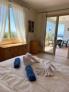 um quarto com uma cama com duas toalhas azuis em Berenike Holiday Apartment em Kissonerga