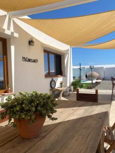 un edificio blanco con toldo sobre una terraza de madera en Mi Cortijo hotel de playa, en Almería