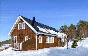 ein Holzhaus im Schnee mit Schnee in der Unterkunft Lovely Home In ydegard With Sauna 
