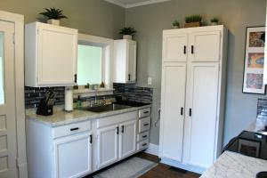 una cocina con armarios blancos y fregadero en The Flower Pot en Lexington