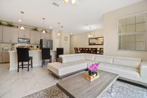 un soggiorno con divano bianco e tavolo di Four Bedrooms close to Disney w Pool 4898 a Kissimmee