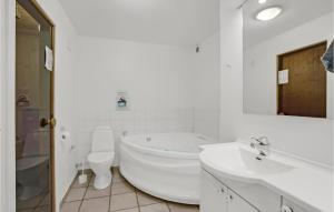 a white bathroom with a tub and a toilet and a sink at 3 Bedroom Beautiful Home In Aabenraa in Aabenraa +16 photos