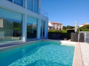 a swimming pool in the backyard of a house at White beach luxury vila in Sagres