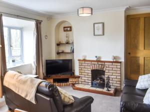 a living room with a couch and a fireplace at Sandwath in Temple Sowerby
