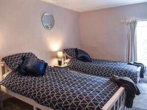 a bedroom with two beds and a mirror at Sandwath in Temple Sowerby