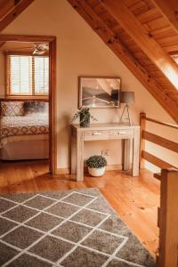 a room with a bed and a desk with a mirror at Otago Cottage in Hobart