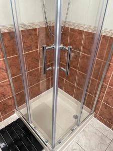 a shower with glass doors in a bathroom at Navaar House Hotel in Penicuik