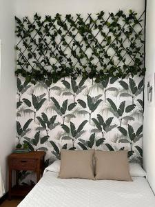 1 dormitorio con 1 cama con pared de flores en Apartamento Plaza Mayor - Torrelavega, en Torrelavega