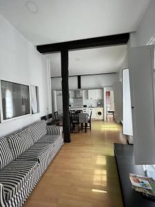Una sala de estar con un sofá y un comedor. en Apartamento Plaza Mayor - Torrelavega, en Torrelavega
