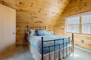 ein Schlafzimmer mit einem Bett in einem Blockhaus in der Unterkunft Peace by Province Lake in Wakefield