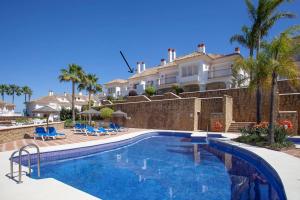 a swimming pool in front of a house at Mediterranean Townhouse CalaGolf in Mijas