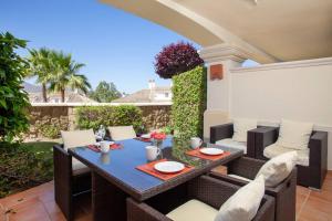 a patio with a table and chairs on a patio at Mediterranean Townhouse CalaGolf in Mijas