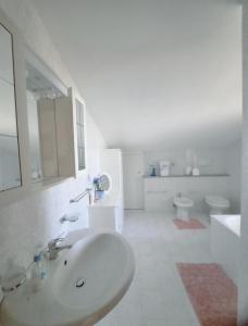 uma casa de banho branca com um lavatório e um WC em Casa di Vacanza Marina di Davoli em Marina di Davoli
