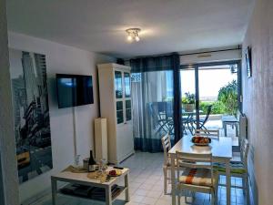 salon ze stołem i jadalnią w obiekcie Appartement cosy, superbe vue mer, piscine. w mieście Sète