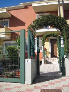 a building with a fence and trees at Sweet Sardinia Apartment in Elmas
