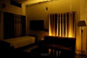 a bedroom with a couch and a bed and a window at Tattva Luxurious Apartment in Varanasi