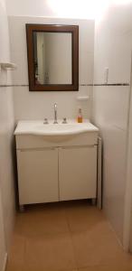 y baño con lavabo blanco y espejo. en Monoambiente Urquiza en Paraná