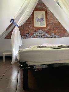 een bed in een kamer met een bakstenen muur bij Cottage sotto il faggio centenario in Ameno