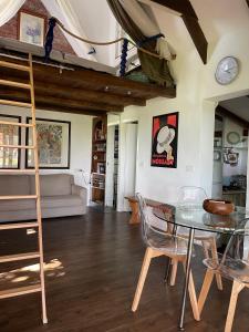 een woonkamer met een glazen tafel en stoelen bij Cottage sotto il faggio centenario in Ameno