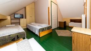 Kleines Zimmer mit 2 Betten und einem TV in der Unterkunft Csillagtúra Panzió in Eger