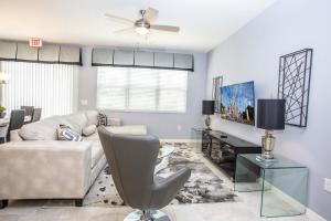 uma sala de estar com um sofá e uma televisão em Four Bedroom Close to Disney 5149A em Kissimmee
