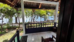a balcony with a view of the ocean from a resort at HAPPY DIVE RETREAT fka Ankermi Happy Dive in Hitokalak