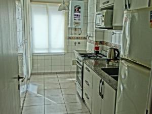 een keuken met witte apparatuur en een tegelvloer bij RECOLETA BS AS in Buenos Aires
