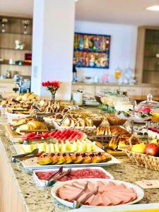 um buffet com muitos pratos de comida numa mesa em Pousada Itália Moderna em Campos do Jordão