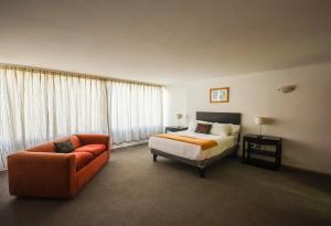 a hotel room with a bed and a couch at Hotel Nogales By Tempo Rent in Santiago