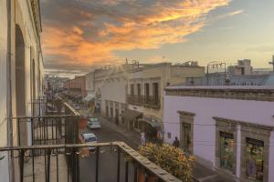 a view of a city street at sunset from a balcony at Hotel El Rincón de Jesusita in Durango