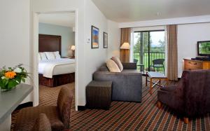 a hotel room with a bed and a living room at The Lodge at Eagle Crest in Redmond