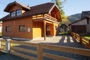 una cabaña de madera con una valla delante en Holiday house with a parking space Jasenak, Karlovac - 20579, en Jasenak