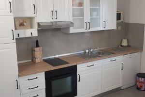 una cocina con armarios blancos y fregadero en Apartments with a parking space Murvica, Brac - 20190 en Bol