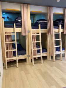 福岡的住宿－博多雲端分享旅館 1，客房设有带梯子的四张双层床。