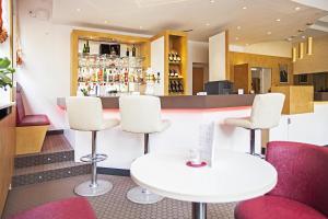 um bar com cadeiras brancas e uma mesa branca em Am Bismarck em Mannheim