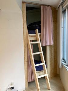 福岡的住宿－博多雲端分享旅館 1，客房内的双层床,带梯子