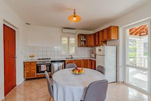 a kitchen with a table with a bowl of fruit on it at Holiday house with a parking space Zrnovo, Korcula - 21067 in Žrnovo