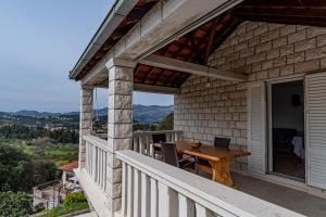 - un balcon d'une maison avec une table en bois dans l'établissement Holiday house with a parking space Zrnovo, Korcula - 21067, à Žrnovo