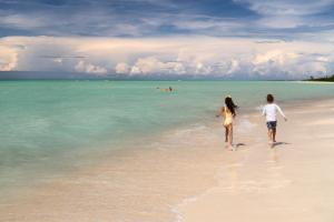 a couple of people walking on the beach at The Ritz-Carlton, Aruba in Palm-Eagle Beach