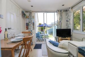 a kitchen and living room with a table and a couch at Respryn in Mevagissey