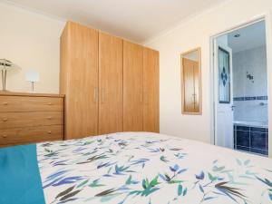 a bedroom with a bed and a dresser and a window at Respryn in Mevagissey