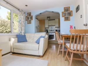 a living room with a white couch and a table at Respryn in Mevagissey