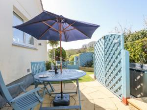 a table with an umbrella on a patio at Respryn in Mevagissey