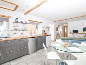 a kitchen and living room with a table and chairs at The Milk Shed in Plymtree